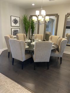 a dinning room table with chairs and a large mirror in the middle of it