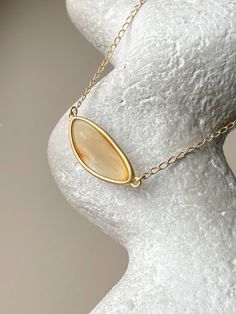 Embrace the captivating allure of the Baltic sea with this chic, elliptical amber pendant. Each piece showcases a pristine slice of natural Baltic amber, renowned for its warmth and depth, encased in a sophisticated gold-plated sterling silver frame. This pendant is the essence of elegance, designed to add a touch of timeless sophistication to any outfit. Its unique organic patterns ensure that no two pendants are alike, offering you an exclusive piece of the earth's beauty. Sterling silver, amber, gold plated Chain length 15 - 16.5" Stone size 1,06" Weight 0,22 oz