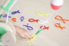 a child is playing with scissors and other crafting supplies on a table, while the toddler's hands are pointing at them