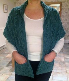 a woman standing in a kitchen wearing a green knitted cardigan