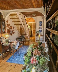 a living room filled with lots of furniture and flowers on top of a blue rug