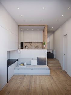 a white couch sitting in the middle of a living room next to a wooden floor