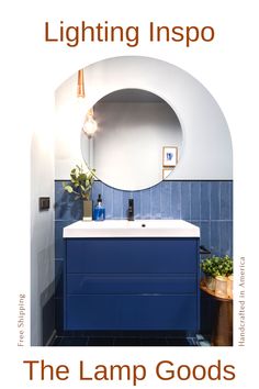 a bathroom with blue tiles and a round mirror on the wall above the sink, along with a potted plant