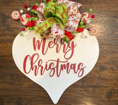 a merry christmas sign hanging on the side of a wooden wall with candy and candies