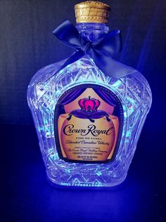 a blue bottle that is sitting on a table in front of a black background with the words crown royal written on it