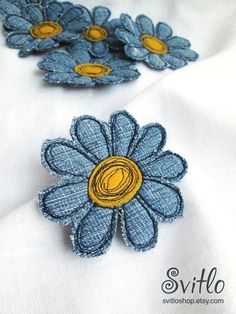 blue and yellow flowers on white fabric with gold center, in the shape of a flower