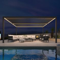 an outdoor living area next to a pool at night