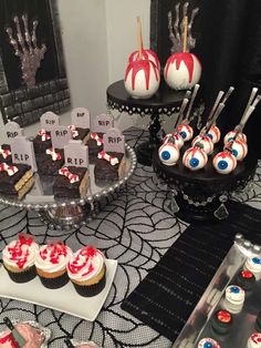 a table topped with lots of cupcakes covered in red and white frosting