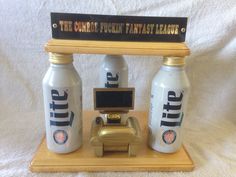 an old fashioned telephone with two bottles on it and a sign that says the gumi flushin fantasy league