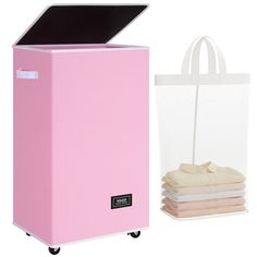 a pink portable laundry hamper next to a white shopping bag and stack of folded towels