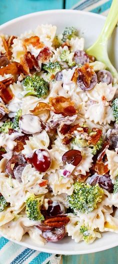 a bowl filled with pasta and broccoli on top of a blue table cloth