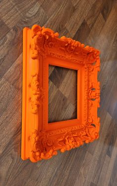 an orange frame sitting on top of a wooden floor