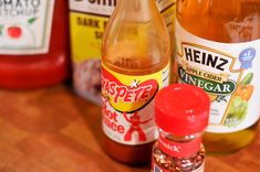 several different types of condiments sitting on a table top, including sauce and ketchup