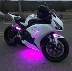 a white motorcycle with purple lights on it