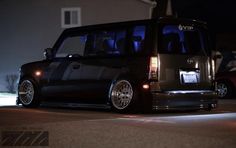 a black minivan parked in front of a house at night