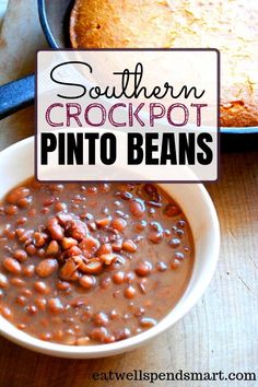 southern crockpot pinto beans in a white bowl next to a skillet and pie