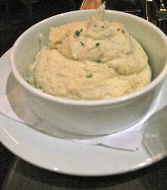 a bowl filled with mashed potatoes on top of a white plate