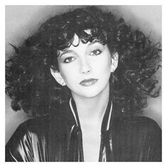 a black and white photo of a woman with long curly hair wearing a leather jacket