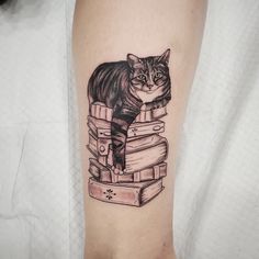 a cat is sitting on top of some books