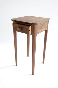 a small wooden table with two drawers on one side and an open drawer on the other