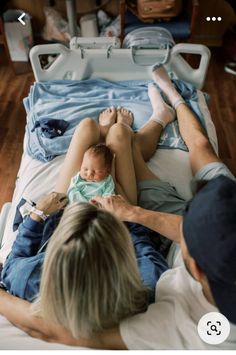 a man and woman laying in bed with a baby