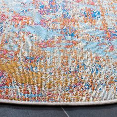 an orange, blue and yellow rug on the floor