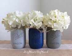 three mason jars with white flowers in them