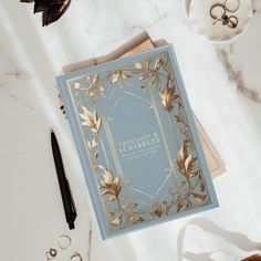 a blue book sitting on top of a white table next to scissors and other items