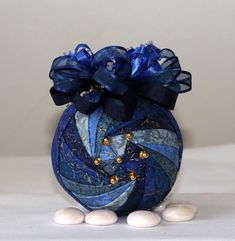 a blue vase filled with white marbles on top of a table