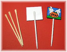 three wooden sticks and two matchesticks on a red surface with a halloween stick in the middle