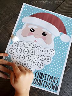 a child's hand holding up a christmas printable