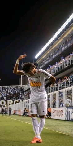 the soccer player is celebrating his goal in front of an empty stadium full of fans