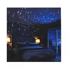 a bed room with a neatly made bed and stars on the ceiling