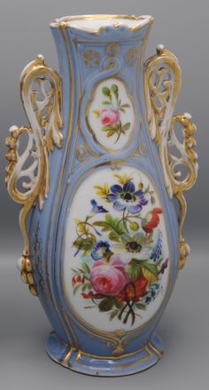 an ornate vase with flowers painted on it's sides and gold trimmings