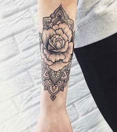 a woman's arm with a rose tattoo on it