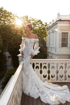 a woman in a wedding dress standing on a balcony