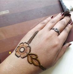 a woman's hand with henna tattoos on her left wrist and the other hand holding a knife