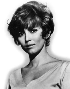 a black and white photo of a woman with short hair wearing a top over her shoulders