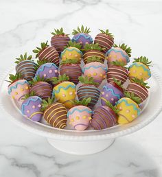 a white bowl filled with chocolate covered strawberries on top of a marble countertop