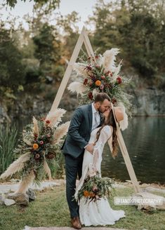 a bride and groom kissing in front of their wedding arch