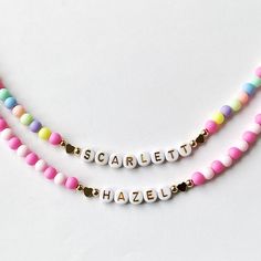 Add a burst of vibrant charm to your little one's outfit with our Bright Colorful Beads Name Necklace! This delightful piece combines the timeless elegance of dainty gold name beads with an array of eye-catching, colorful hued beads. Your child's name is spelled out in gold and adorned with a captivating spectrum of colors, creating a personalized gift that will surely bring smiles. This necklace would make a perfect birthday gift for little girls.  Perfect for Easter too! Colorful acrylic beads strung on wire and accented with Gold letter Beads, 18k plated heart beads and 18k plated gold ball beads. 18K gold hearts or 18K round ball beads.   Choose which style you would like from the drop down menu along with the length of the necklace. Necklace is packaged for gift giving. To see more Ki Playful Beaded Charm Necklaces For Gifts, Playful Beaded Charm Necklace For Gifts, Playful Beaded Charm Necklaces As Gifts, Playful Pink Charm Necklaces For Friendship, Playful Pink Charm Necklace For Friendship, Cute Personalized Multicolor Charm Necklaces, Playful Beaded Jewelry For Mother's Day, Fun Multicolor Personalized Charm Necklaces, Pink Letter Beads Fun Necklaces