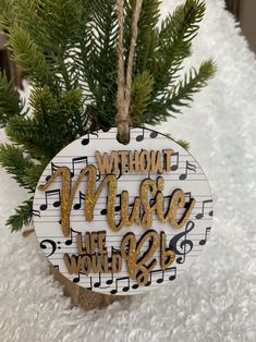 a wooden ornament with musical notes hanging from it's side on a tree