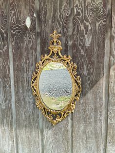 a mirror hanging on the side of a wooden fence