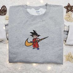 The Swoosh x Goku Kid Anime Embroidered Hoodie is a must-have for any anime fan. With its intricate embroidery featuring Goku, this hoodie is a true collector’s item. Made from high-quality materials, it offers comfort and durability. Whether you’re gifting it to a family member or keeping it for yourself, this hoodie is the perfect way to showcase your love for anime. Get ready to turn heads and make a statement with this unique and stylish hoodie. The Best Gift for Family Embroider Gojo Nike Hoodie, Character Print Hoodie Sweatshirt For Fans, Character Print Fan Merchandise Hoodie, Character Print Hoodie For Fans With Crew Neck, Fan Merchandise Hoodie With Character Print, Crew Neck, Crew Neck Hoodie With Character Print For Fans, Sporty Hoodie Sweatshirt With Character Print, Sporty Hoodie With Cartoon Print And Crew Neck, Sporty Crew Neck Hoodie With Cartoon Print