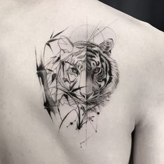 a tiger tattoo on the back of a man's upper half and chest with geometric shapes