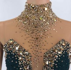 the back of a dress with gold and black beads on it