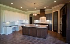 a large kitchen with an island in the middle and lots of cabinets on both sides