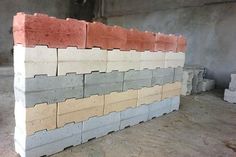 several different colored bricks stacked on top of each other in an unfinished room with cement walls and concrete flooring