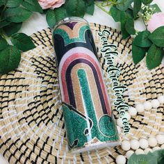 a canister sitting on top of a wicker table next to flowers and beads