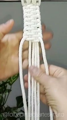 two hands are pulling the end of a piece of white string